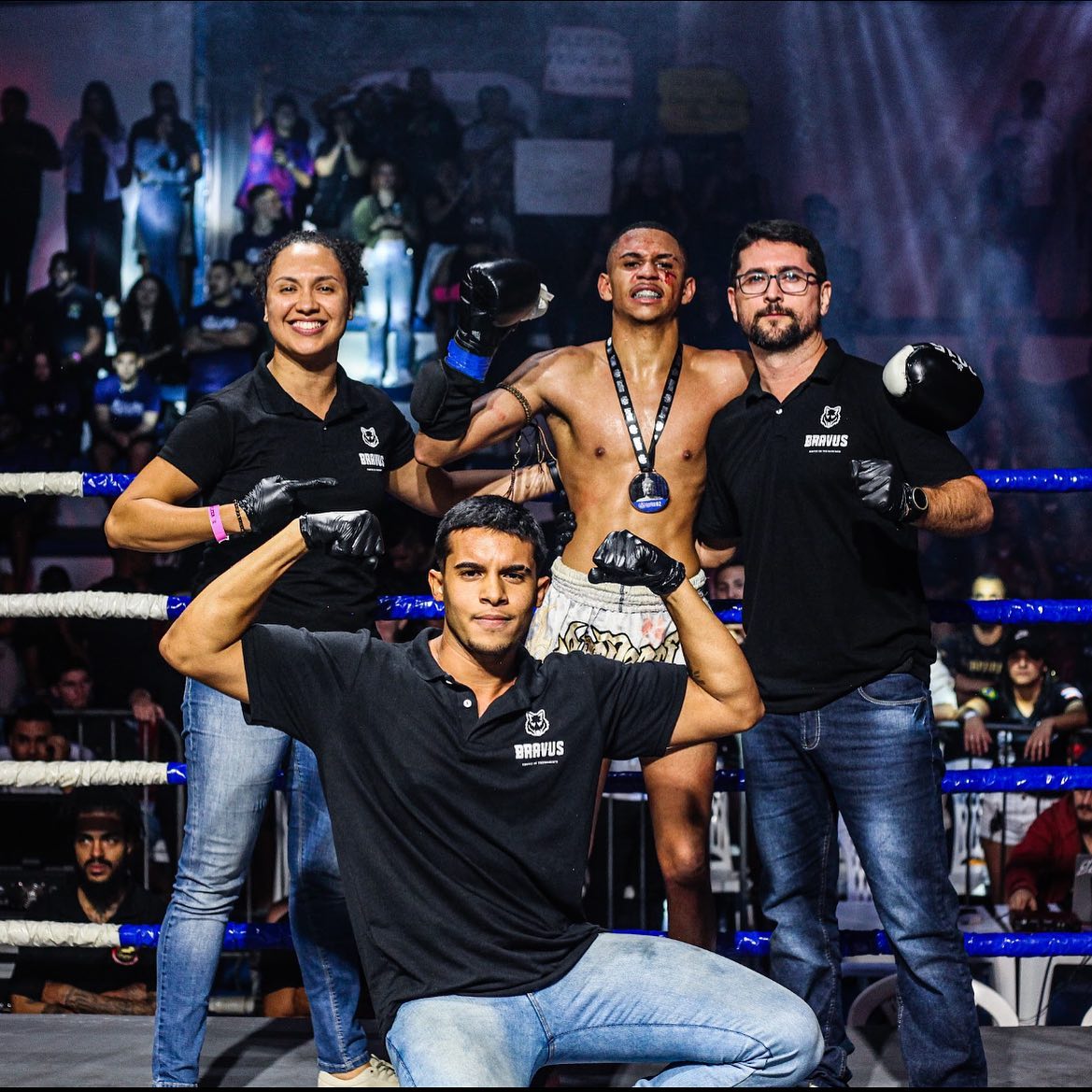 Atleta Bravus campeão de Muay Thai com medalha e equipe técnica